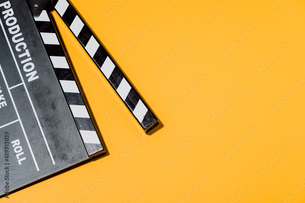 Obraz premium Film clapperboard on yellow studio background