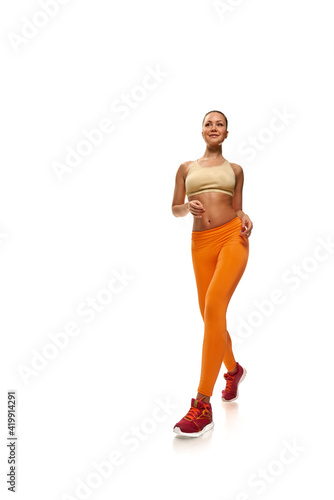 Portrait of young healthy strong sportswoman jogging on white background © Denys Kurbatov