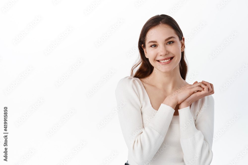 Portrait of beautiful caucasian woman clap hands and smiling pleased, looking thankful at camera, receive gift and rejoice, standing against white background Portrait of beautiful caucasian woman clap hands and smiling pleased, looking thankful at camera, receive gift and rejoice, standing against white background
