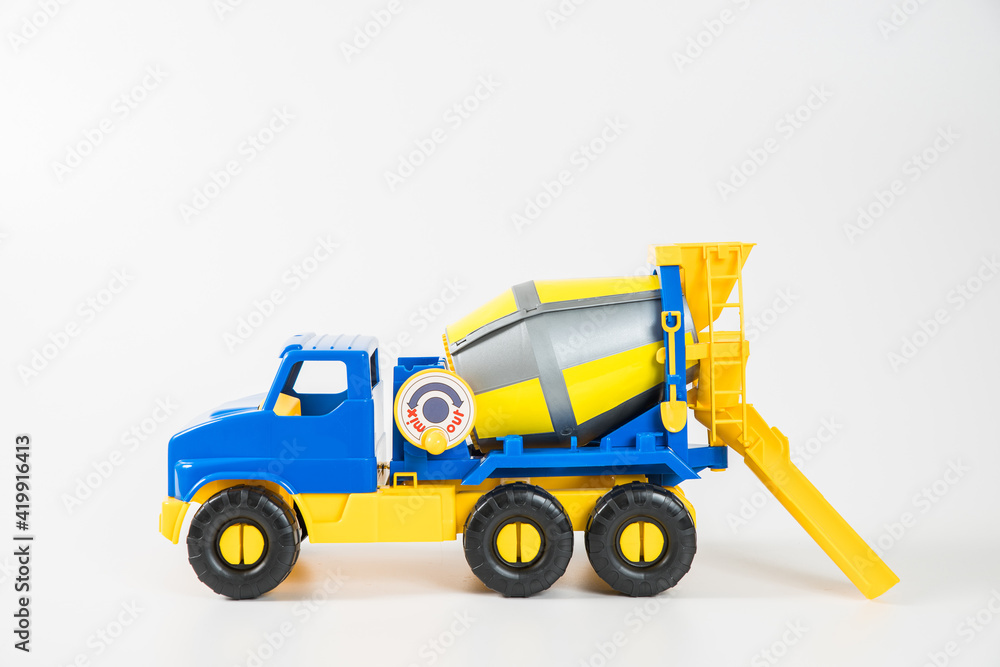 Plastic car. Toy model isolated on a white background. Yellow-blue concrete truck. Plastic car. Toy model isolated on a white background. Yellow-blue concrete truck.