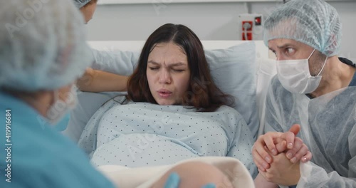 Pregnant young woman pushing to give birth in hospital photo