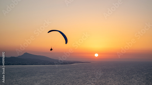 Parachuting - Paragliding in sunset © kanellos