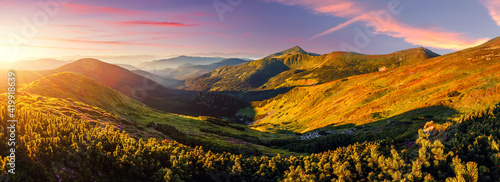 Panorama landscape of Carpathian mountains during sunset. Scenic image of fantastic atmosferic scenery with picturesque sky, mountain range under vivid sunlit. Amazing nature scenery. creative image