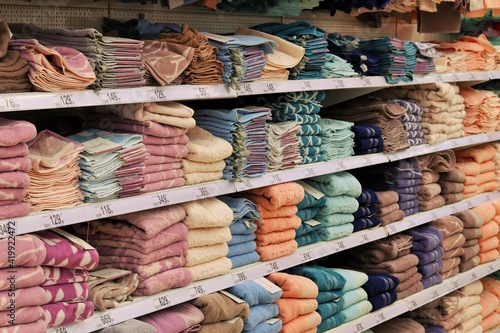 Neatly folded cotton towels on store shelves 
