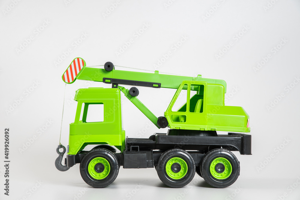 Plastic car. Toy model isolated on a white background. Green truck mounted crane.