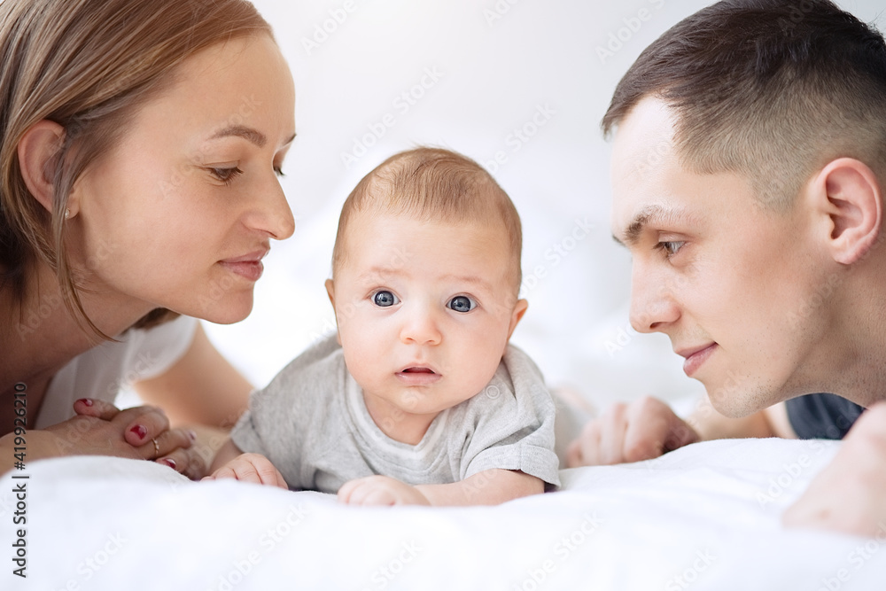 Smiling mother and father with a newborn baby in bed Smiling mother and father with a newborn baby in bed