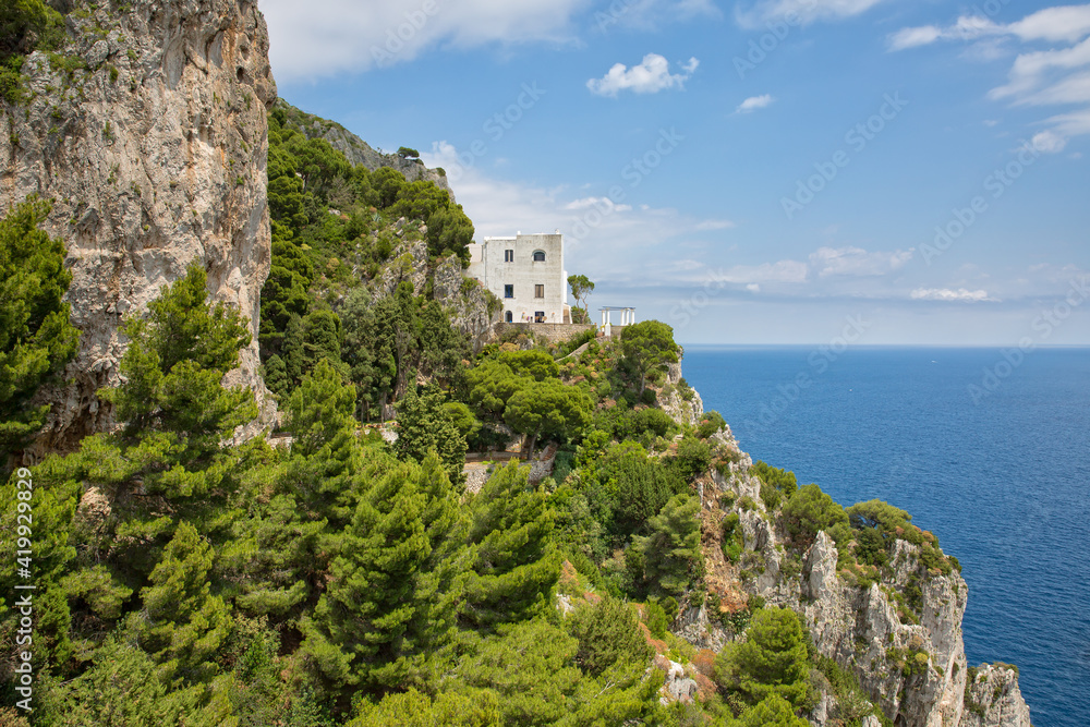 Traditional italian house situated on a cliff. Landscape view with trees and cliffs and a fantastic view of the Tyrrhenian Sea in Capri Island, Italy