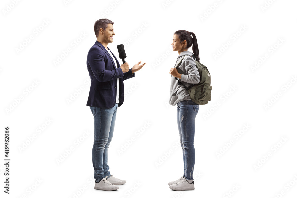 Male reporter with a microphone talking to a female student Male reporter with a microphone talking to a female student