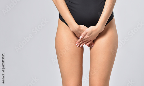 Woman in black underwear holds hands in crotch, feminine health and hygiene concept
