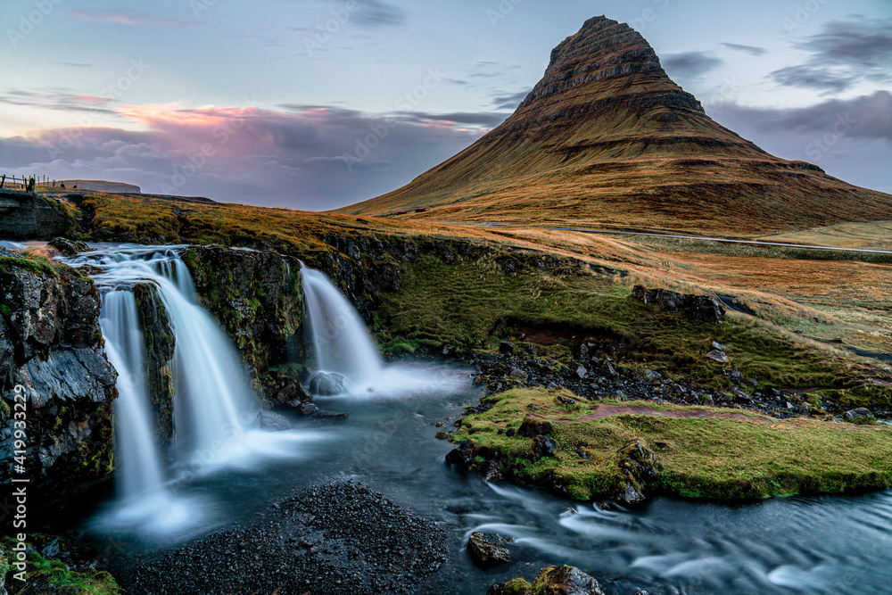 The famous Kirkjufell mountain in western Iceland also commonly referred to by a famous wizards hat. Shot during sunset, long exposure and vibrant colors The famous Kirkjufell mountain in western Iceland also commonly referred to by a famous wizards hat. Shot during sunset, long exposure and vibrant colors