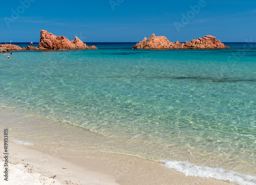 Fototapeta Naklejka Na Ścianę i Meble -  The red rocks in the northern edge of the long beach called Spiaggia di Cea, near Arbatax (Sardinia, Italy)