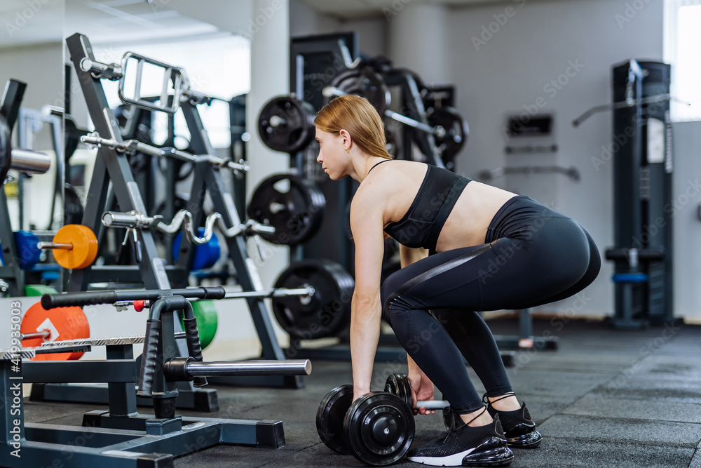 Woman has workout in gym with sports equipment. Young and fit. Female with nice body, athletic form. Healthy fitness life concept.
