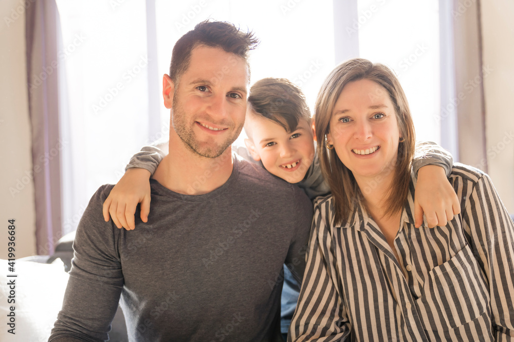 Fototapeta premium married couple and son sit on the sofa at home