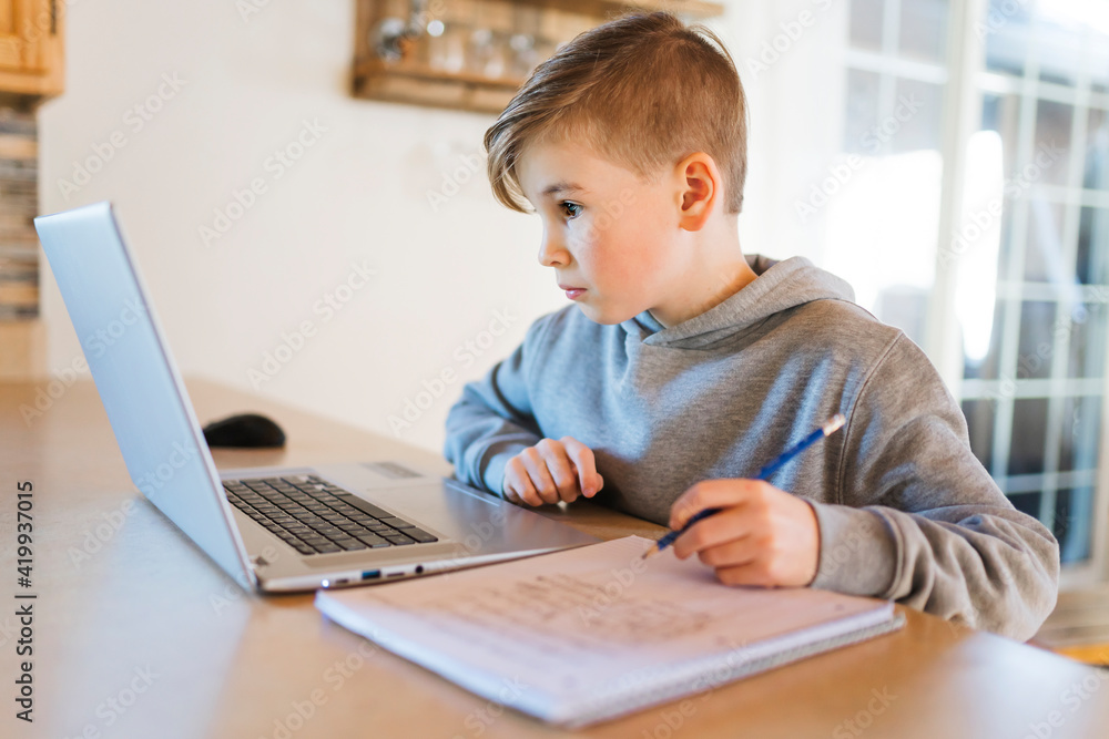Teenager boy doing his homework at desk indoors Teenager boy doing his homework at desk indoors