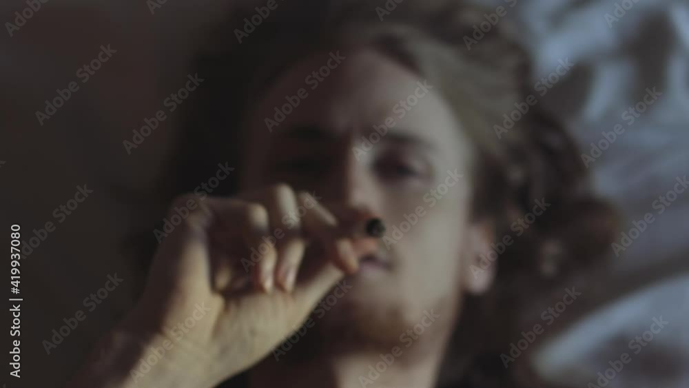 Man Lying Down Smoking a Cannabis Joint Man Lying Down Smoking a Cannabis Joint