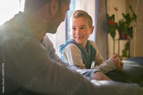 Photos father and son sit on the sofa at home