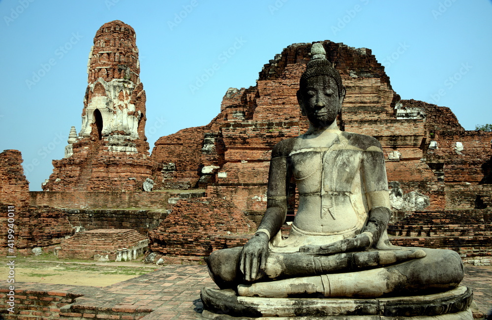 THAILAND AYUTTHAYA. Wat Phra Mahatat, built in the 14th century, area dotted with small chedis and Khmer towers notably has a head of a Buddha statue where tree roots have grown around THAILAND AYUTTHAYA. Wat Phra Mahatat, built in the 14th century, area dotted with small chedis and Khmer towers notably has a head of a Buddha statue where tree roots have grown around
