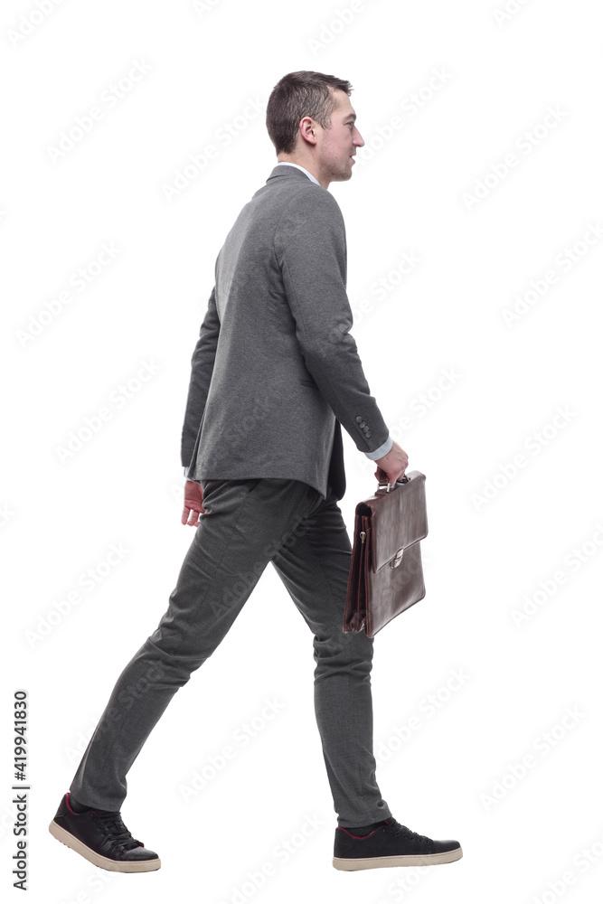 in full growth. a business man with a leather briefcase striding forward. in full growth. a business man with a leather briefcase striding forward.