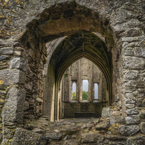 View through window to Hore Abbey abandoned interior with decorative arches. Located next to Rock of Cashel castle, County Tipperary, Ireland