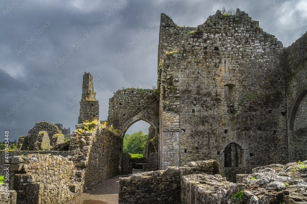 Closeup on exterior walls of ruined and abandoned Hore Abbey with dramatic storm sky. Located next to Rock of Cashel castle, County Tipperary, Ireland