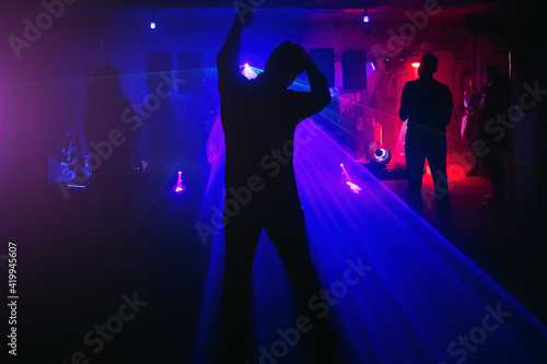 Silhouette of dancing people in the night club disco