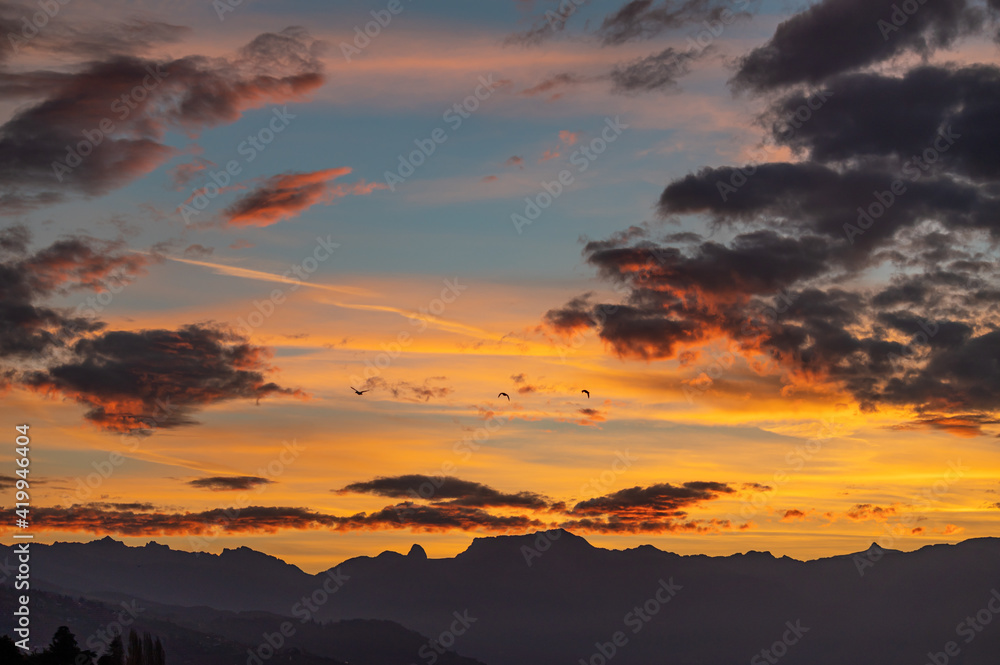 Sunset over the mountains. Dramatic sky at sunset with red, yellow and orange colors. Lausanne, Switzerland.