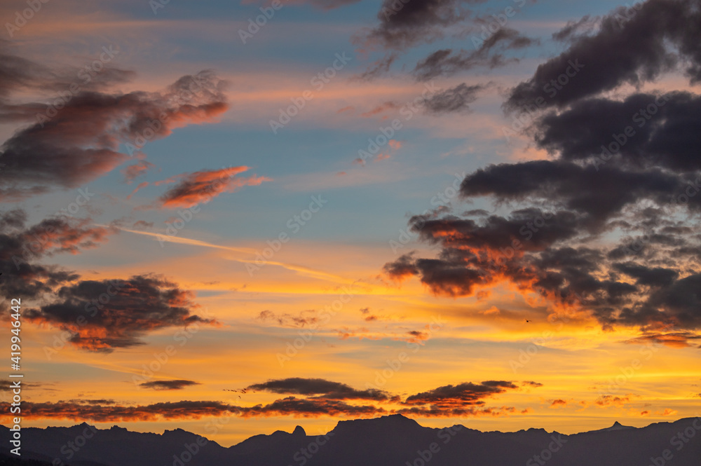 Sunset over the mountains. Dramatic sky at sunset with red, yellow and orange colors. Lausanne, Switzerland.