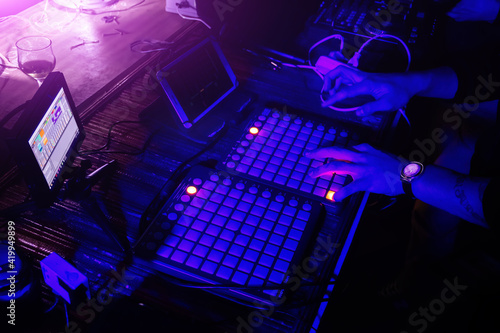 Photography DJ playing synthesizer and mixing music in the night club