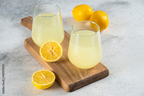 Two cups of fresh lemonade on a wooden board
