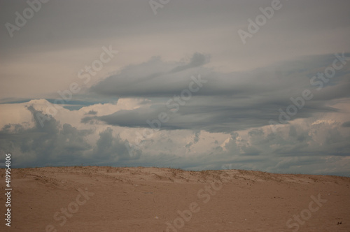 Nubes oscuras tras la duna de la playa