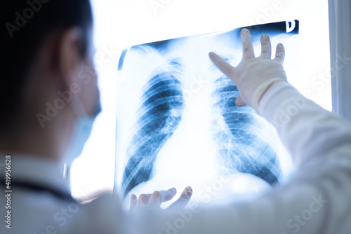 Pulmonologist looking at lung x-ray prescribing treatment to patient, healthcare