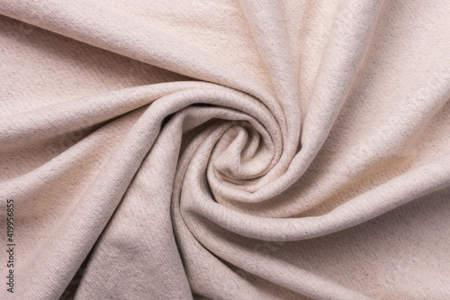 The fabric is in a beige color, twisted in a spiral. Top view