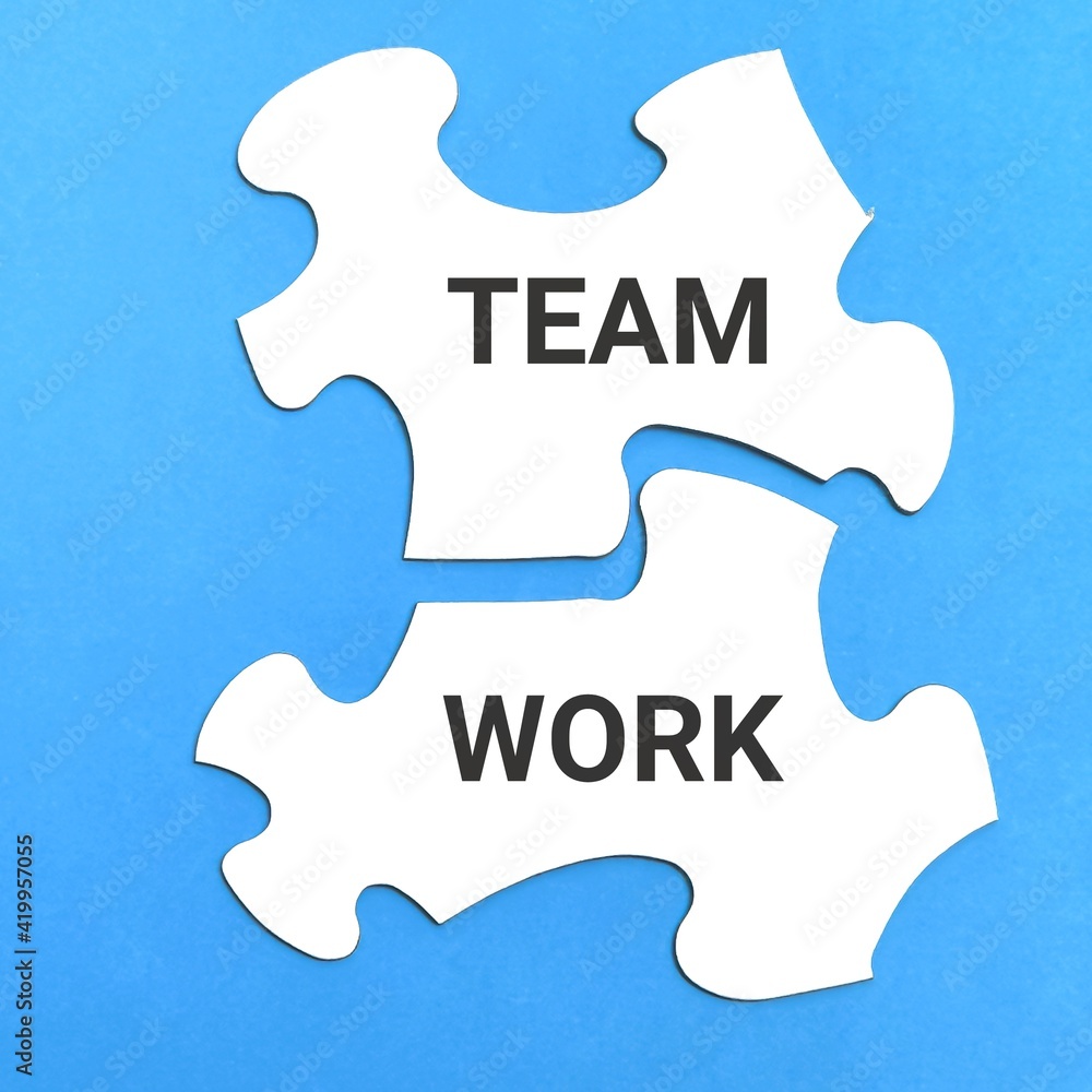 Teamwork concept. White jigsaw puzzles written TEAMWORK isolated on blue background. Teamwork concept. White jigsaw puzzles written TEAMWORK isolated on blue background.