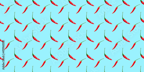 Red hot chili peppers seamless pattern isolated on blue background. Top view. Flat lay. Banner
