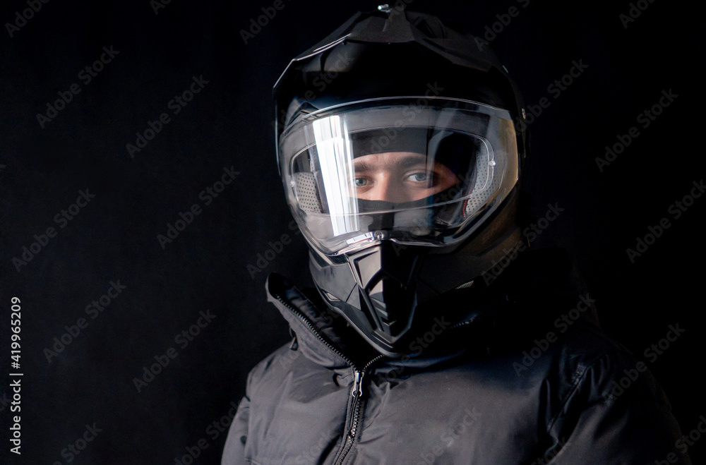 Motorcyclist wearing a black dual-purpose motorcycle helmet with a black jacket.