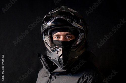 Motorcyclist wearing a black dual-purpose motorcycle helmet with a black jacket.