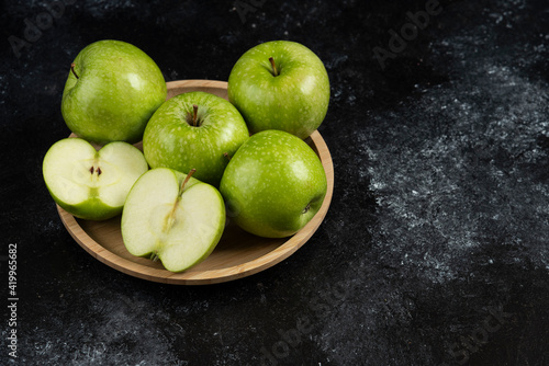 Whole and sliced ripe green apples on wooden plate © azerbaijan-stockers