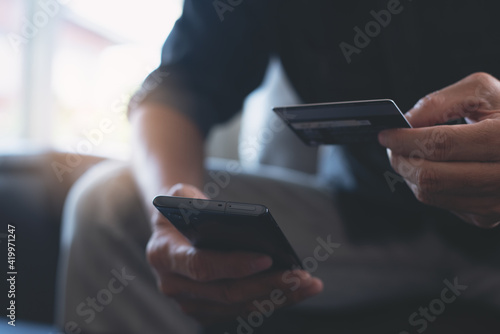 Man using credit card and mobile phone for online shopping and internet payment via mobile banking app