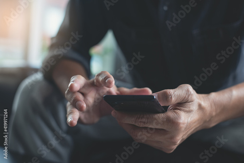 Close up of man using mobile phone at home, close up