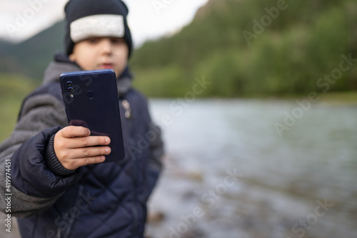 little boy using smart phone outdoors