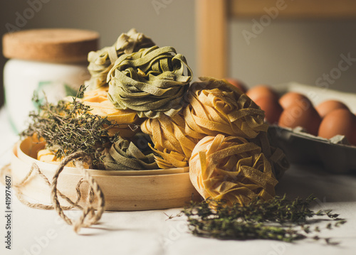 Dry Taglatelle Pasta on the wooden table with bright background photo