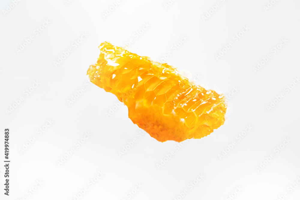a piece of honeycomb in the air on a white background a piece of honeycomb in the air on a white background