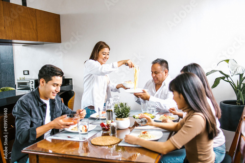 latin family eating pasta together in home in Mexico city