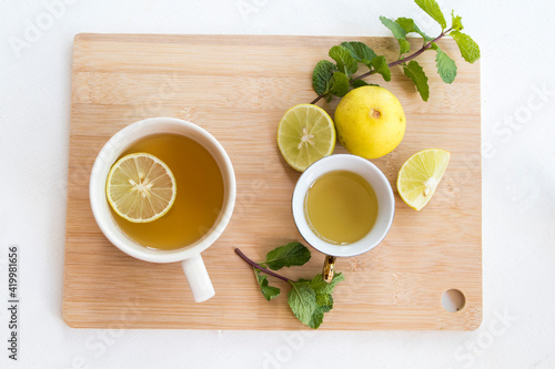 herbal healthy drinks hot tea honey lemon for health care with peppermint leaf and lemon slice for relaxation arrangement flat lay style on background wooden