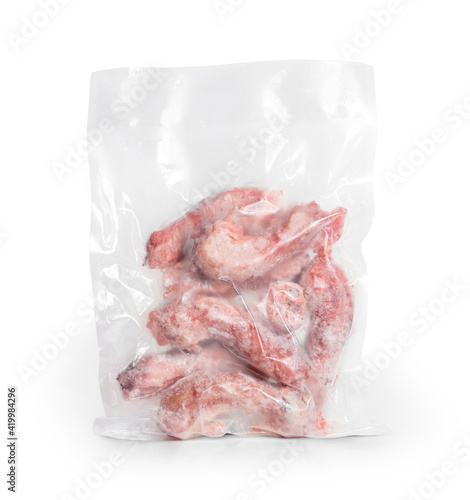 1 lb frozen chicken necks in vacuum sealed package. Many raw large chicken necks. Concept for raw food diet for cats, dogs and pets. Bones prevent plaque buildup and help dental health. Isolated. photo