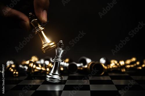 Obraz na plátně Close up hand choose king chess to challenge battle fighting on chess board concepts of leadership and business strategy and human personal organization risk management
