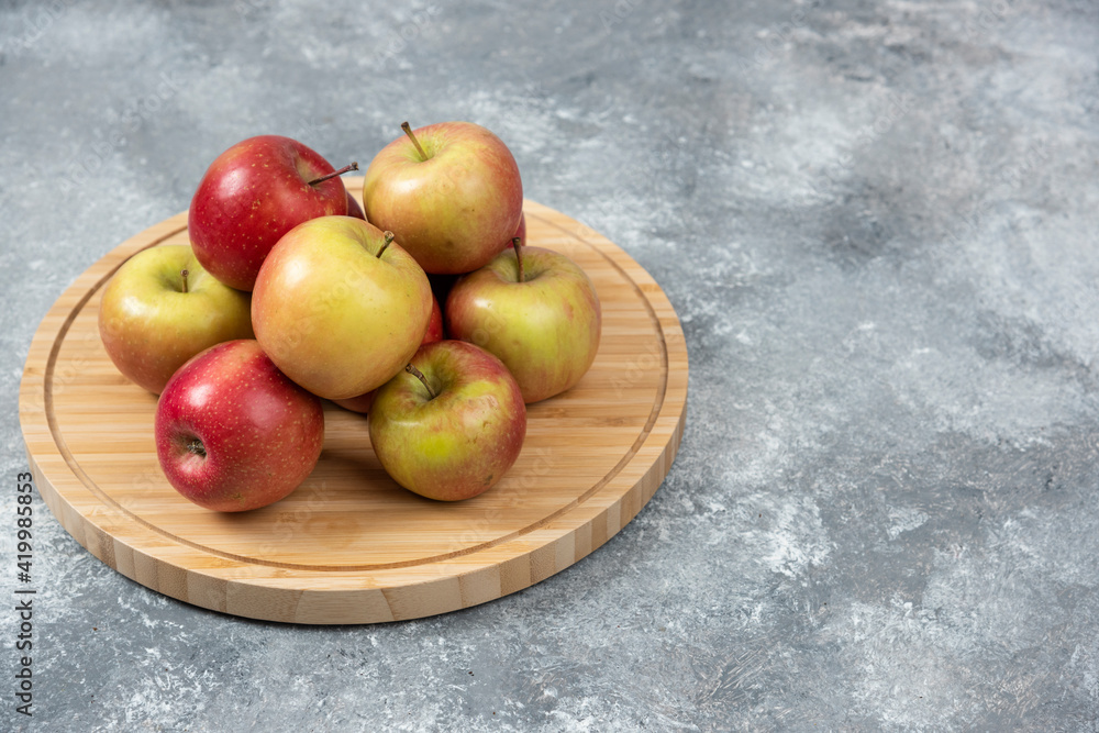 Bunch of fresh ripe apples placed on wooden board Bunch of fresh ripe apples placed on wooden board