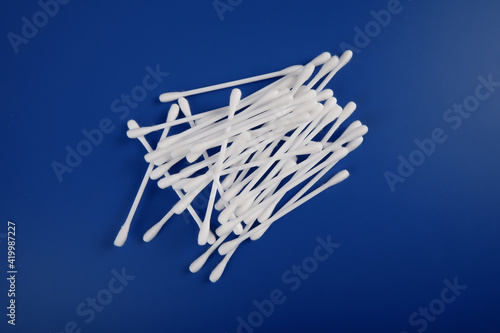 a pile of cotton swabs lies on a blue background