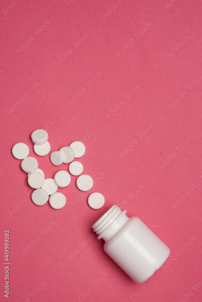 Open jar with pills on pink background coldspace top view Open jar with pills on pink background coldspace top view