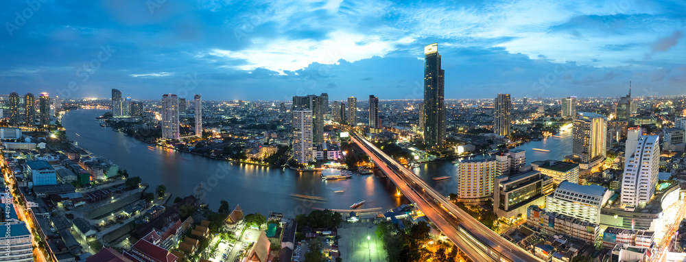 Obraz premium Bangkok Transportation at Dusk with Modern Business Building along the river